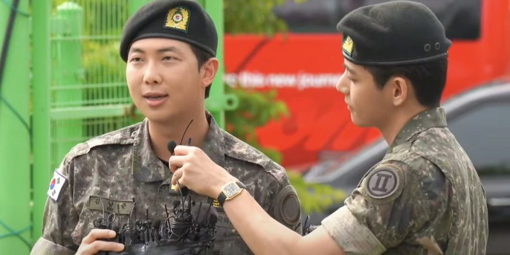 BTS RM talking to the press while V holding the mic at the Sports Park in Chuncheon after discharging from the military on June 10, 2025